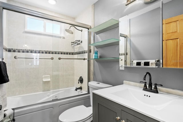 full bathroom featuring toilet, vanity, and enclosed tub / shower combo