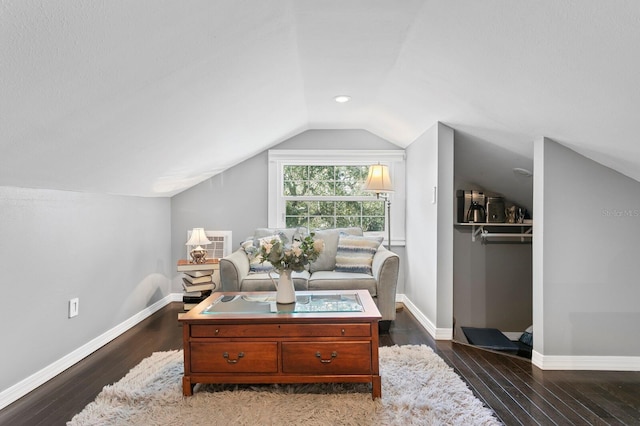 living area featuring vaulted ceiling and dark hardwood / wood-style flooring