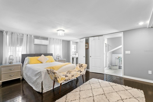 bedroom with dark wood-type flooring and connected bathroom