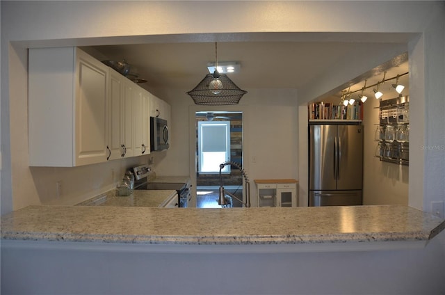 kitchen featuring appliances with stainless steel finishes, white cabinets, pendant lighting, sink, and kitchen peninsula