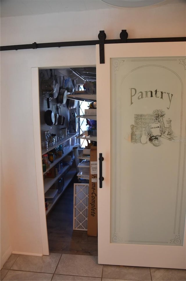 wine room featuring a barn door and light tile patterned floors