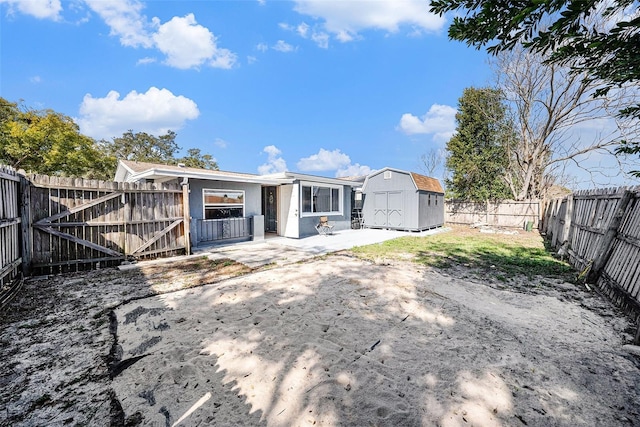 rear view of property featuring a patio area and a shed