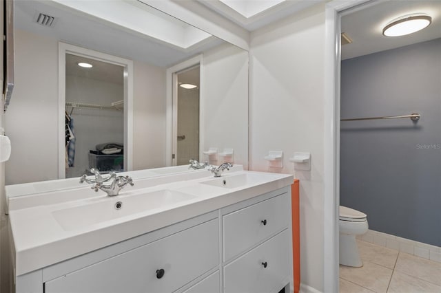 full bathroom featuring double vanity, visible vents, toilet, a sink, and tile patterned flooring