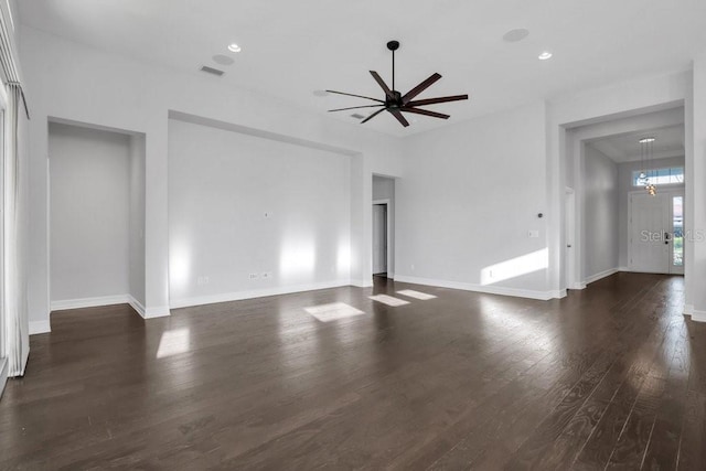 unfurnished living room featuring dark wood-style flooring, visible vents, and baseboards