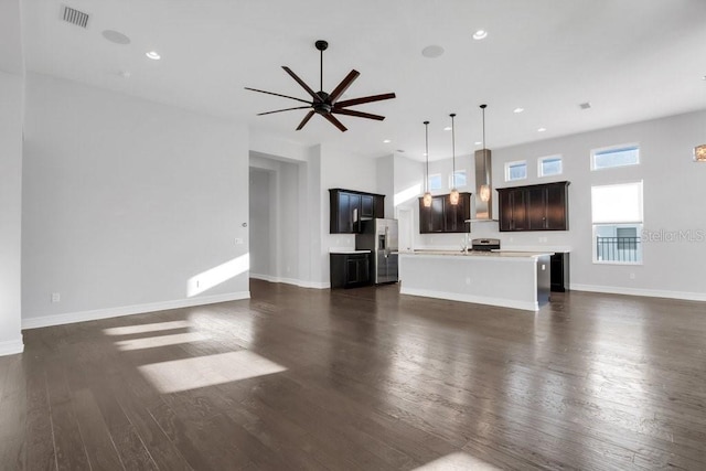 unfurnished living room featuring ceiling fan, recessed lighting, visible vents, baseboards, and dark wood finished floors