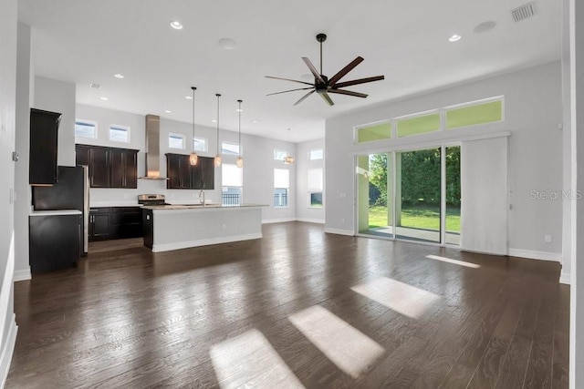 unfurnished living room featuring baseboards, visible vents, dark wood-style flooring, and recessed lighting