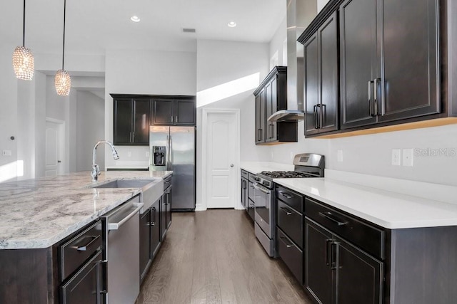 kitchen with visible vents, appliances with stainless steel finishes, wood finished floors, decorative light fixtures, and a sink