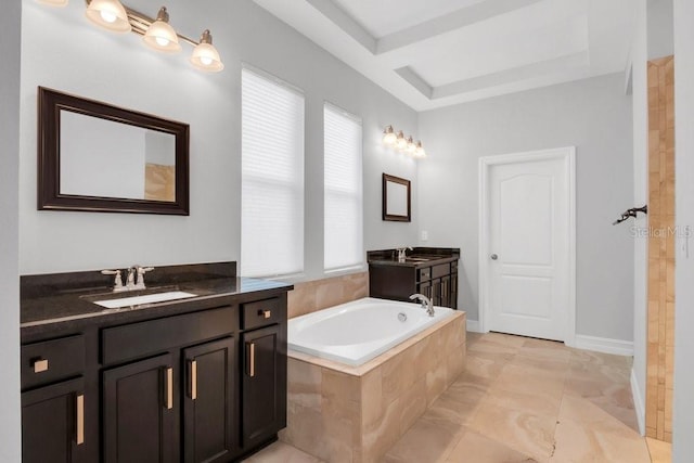 full bath featuring tiled bath, baseboards, two vanities, and a sink