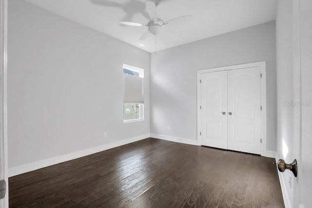 unfurnished bedroom with dark wood-style floors, a ceiling fan, baseboards, and a closet