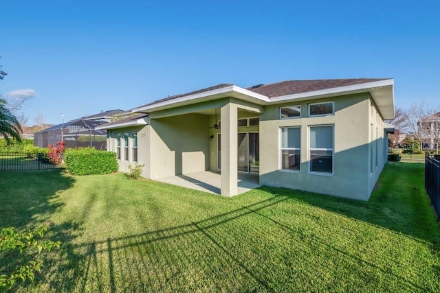 rear view of property with a lanai, a lawn, a patio, and stucco siding