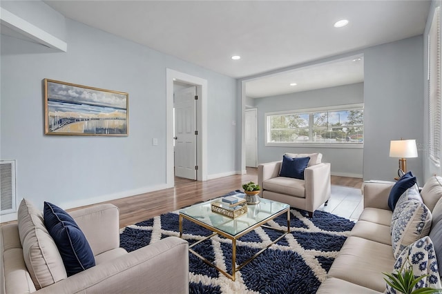 living area with light wood finished floors, recessed lighting, visible vents, and baseboards