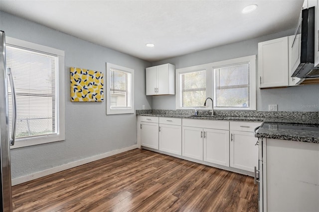 kitchen featuring stainless steel fridge, baseboards, white cabinets, dark wood-style floors, and a sink