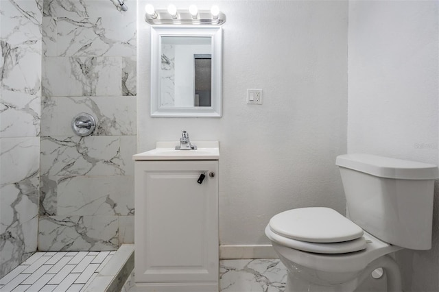 full bath featuring baseboards, tiled shower, toilet, marble finish floor, and vanity