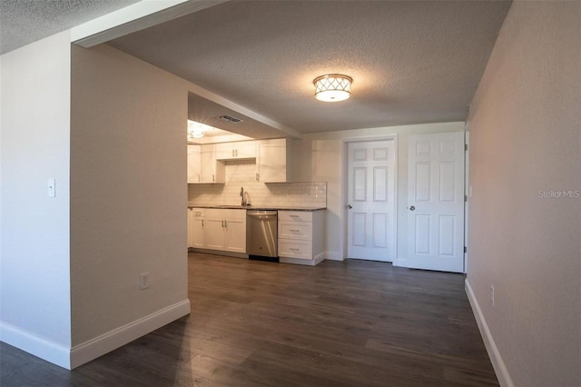 kitchen with dark wood-type flooring, sink, white cabinetry, stainless steel dishwasher, and decorative backsplash