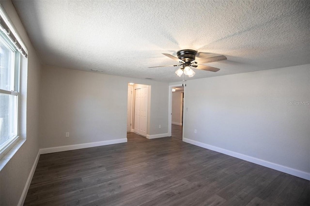 unfurnished room featuring ceiling fan, dark wood-type flooring, and a textured ceiling