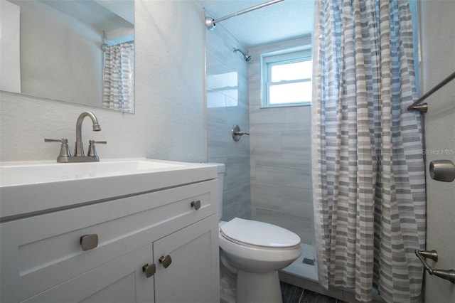 bathroom featuring walk in shower, vanity, and toilet