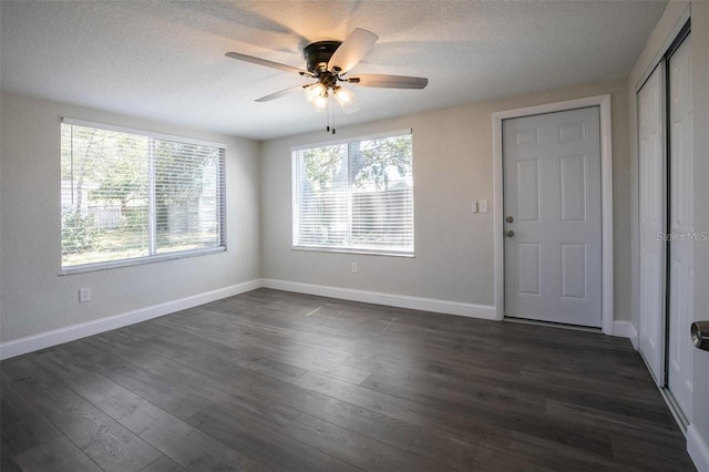 unfurnished room featuring ceiling fan, dark hardwood / wood-style floors, and a textured ceiling