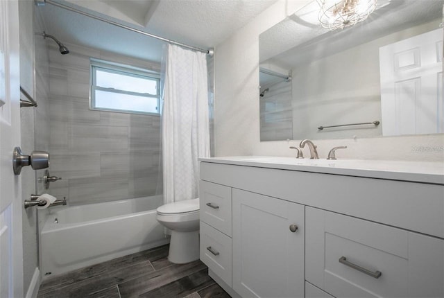 full bathroom with shower / tub combo with curtain, vanity, toilet, and a textured ceiling