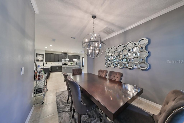 dining area with an inviting chandelier, crown molding, light tile patterned floors, and sink