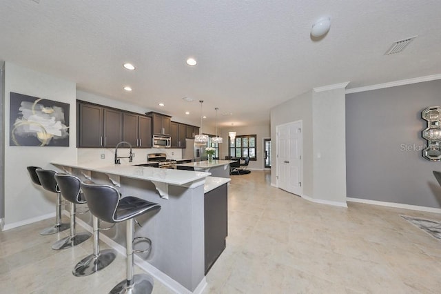 kitchen featuring a kitchen breakfast bar, stainless steel appliances, kitchen peninsula, hanging light fixtures, and dark brown cabinetry