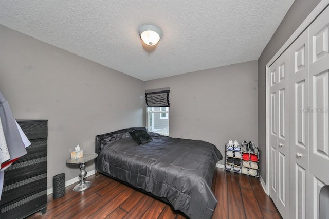 bedroom with dark hardwood / wood-style flooring, a textured ceiling, and a closet