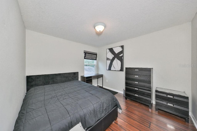 bedroom featuring a textured ceiling and dark wood-type flooring