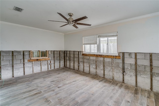 spare room with crown molding, light hardwood / wood-style floors, and ceiling fan