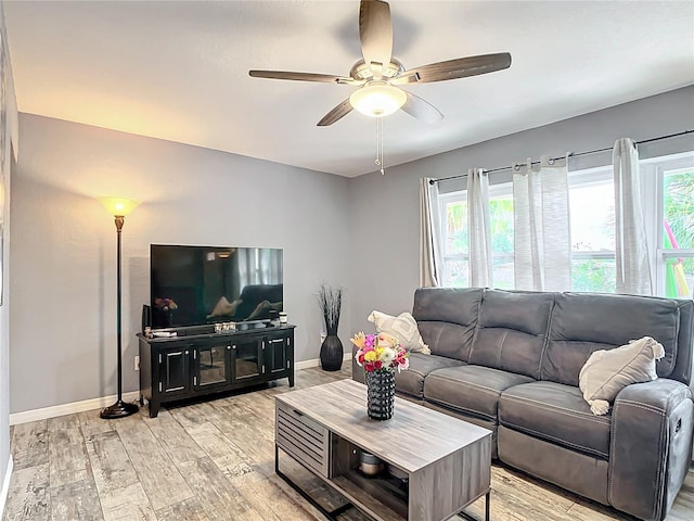 living room with plenty of natural light, ceiling fan, and light hardwood / wood-style flooring