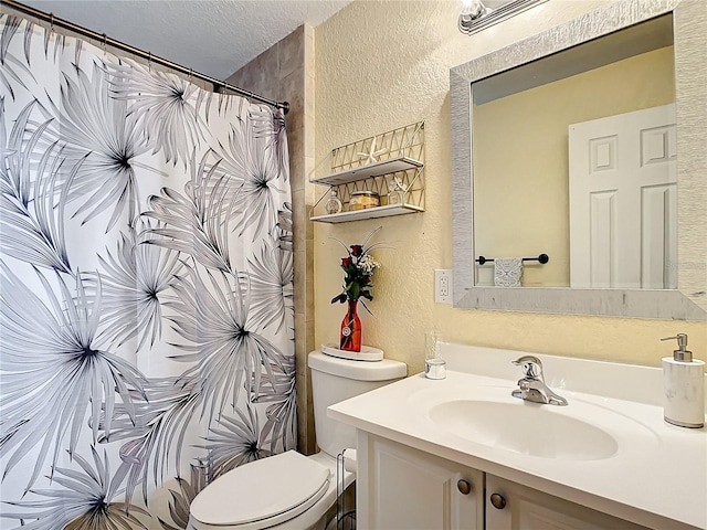 bathroom with vanity, a textured ceiling, and toilet