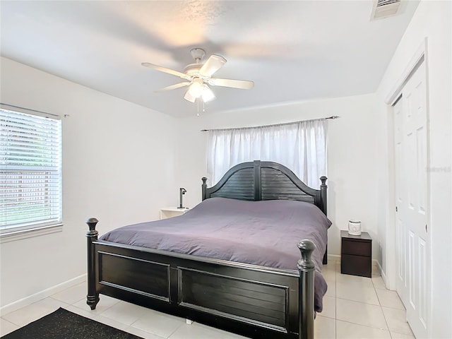 bedroom with a closet, ceiling fan, and light tile patterned flooring