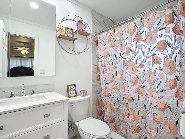 bathroom with toilet, vanity, ceiling fan, walk in shower, and crown molding