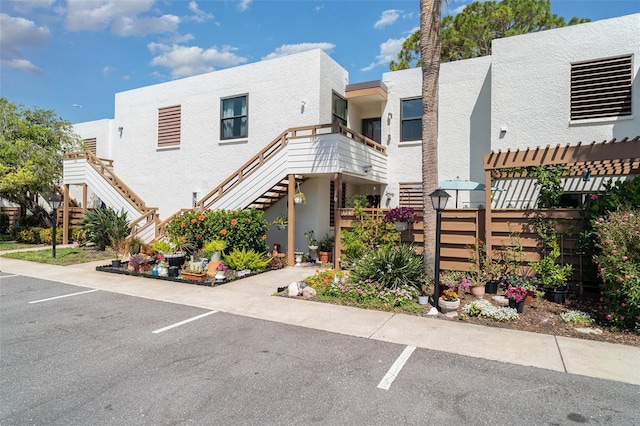127 Tidewater Dr Unit 127, Bradenton, FL 34210 - view of front of house with uncovered parking, stucco siding, and stairs