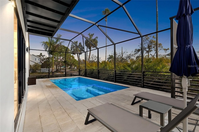 view of swimming pool with glass enclosure and a patio