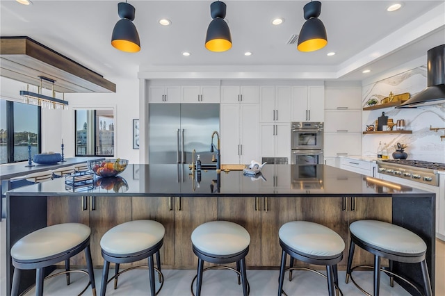 kitchen featuring a center island, white cabinetry, a kitchen bar, and stainless steel appliances