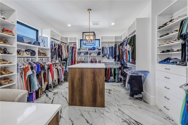 spacious closet featuring a notable chandelier