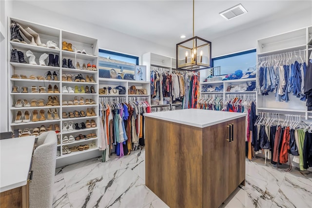 walk in closet with an inviting chandelier