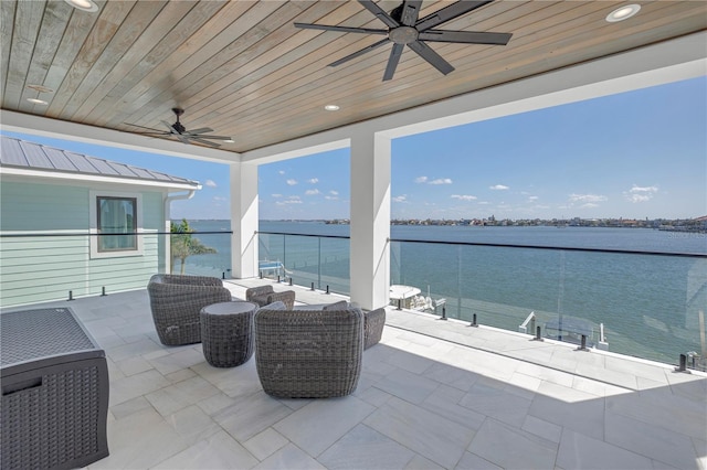 view of patio with outdoor lounge area, a water view, and ceiling fan