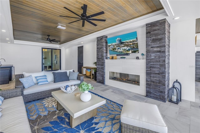 view of patio / terrace featuring ceiling fan and an outdoor living space with a fireplace