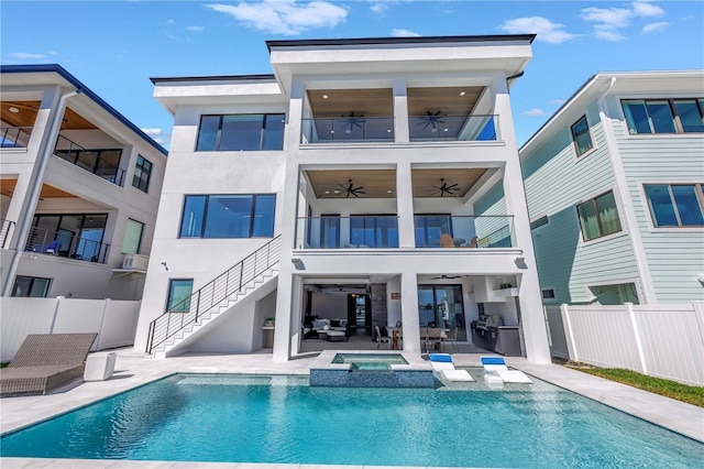 rear view of house featuring a patio, outdoor lounge area, a swimming pool with hot tub, and ceiling fan