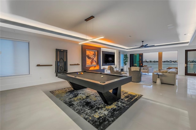 recreation room with ceiling fan, a water view, billiards, and a raised ceiling