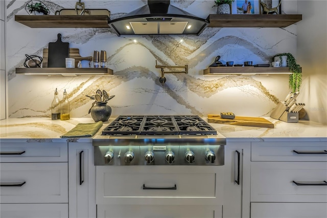 kitchen featuring white cabinetry, stainless steel gas cooktop, light stone countertops, island exhaust hood, and decorative backsplash