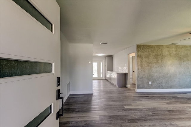 interior space featuring baseboards, visible vents, and dark wood-style flooring