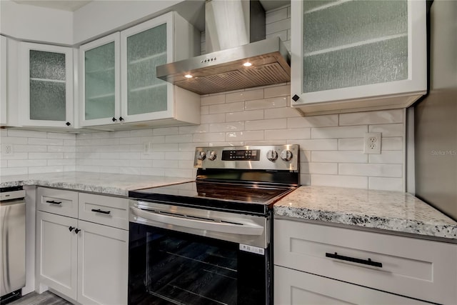 kitchen with stainless steel range with electric stovetop, light stone counters, wall chimney exhaust hood, and tasteful backsplash