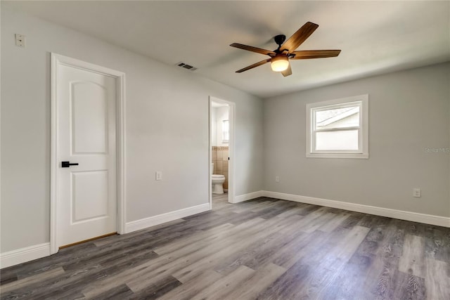 unfurnished bedroom featuring baseboards, visible vents, and dark wood-style flooring