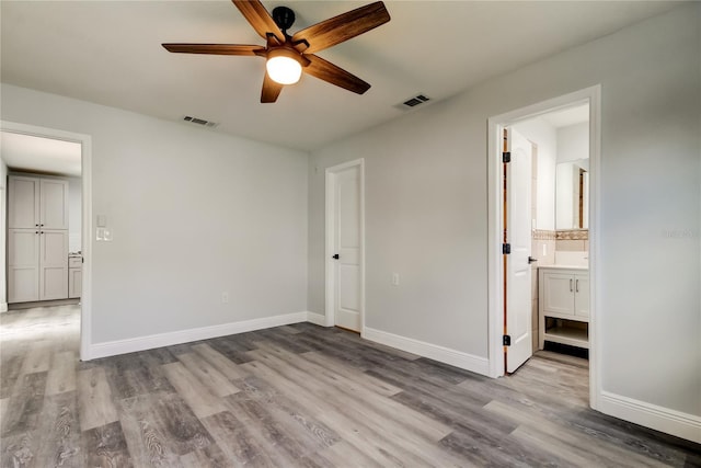 unfurnished bedroom featuring wood finished floors, visible vents, and baseboards