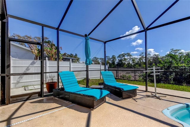 view of patio with glass enclosure and a fenced backyard