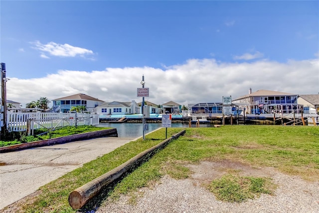 view of dock featuring a residential view, a water view, and fence