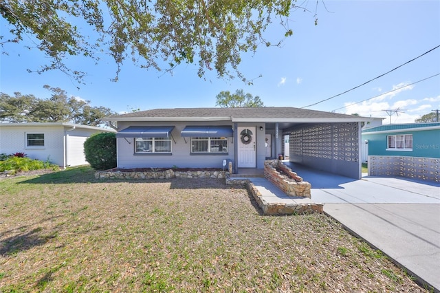 single story home with a front lawn, a carport, and concrete driveway