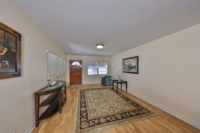 foyer with baseboards and light wood-style floors