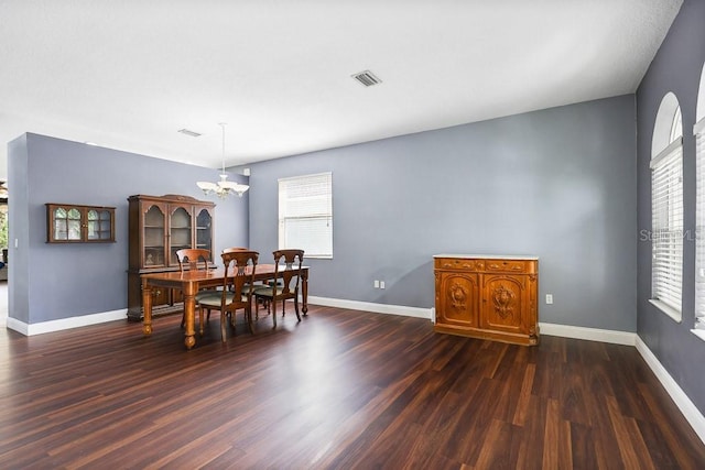 dining space featuring an inviting chandelier and dark hardwood / wood-style flooring